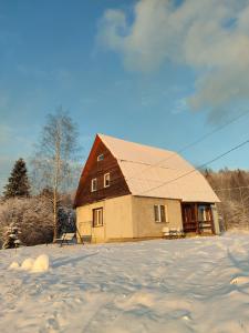 ein Haus mit Dach im Schnee in der Unterkunft Армаден in Slawske