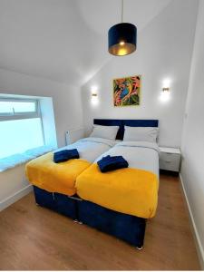two beds with yellow cushions in a bedroom at Blue Door Apartments in Dover