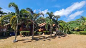 Ban Ai DaoにあるTeak House Lanta-2 Mins Walk To Beachの前にヤシの木がある家