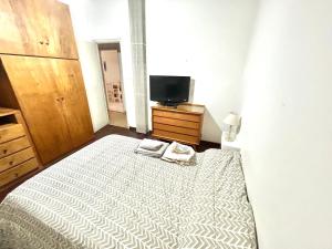 a bedroom with a large bed and a tv at Punto Central Junin in Junín