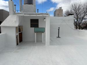 a white building with a sign on the roof at Punto Central Junin in Junín