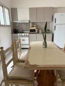 a kitchen with a table and a white refrigerator at Punto Central Junin in Junín +8 photos