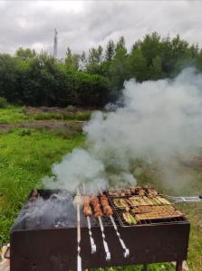 ein Grill mit viel Rauch und Würstchen in der Unterkunft Армаден in Slawske