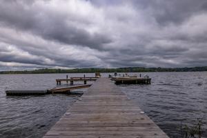a wooden dock in the water on a cloudy day at Cozy Lake Getaway with Firepit, Lake Access, Theatre in Boydton