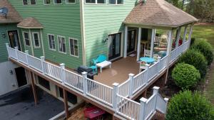 an aerial view of a green house with a deck at Cozy Lake Getaway with Firepit, Lake Access, Theatre in Boydton