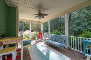 a screened in porch with a ceiling fan and a swing at Cozy Lake Getaway with Firepit, Lake Access, Theatre in Boydton +46 photos