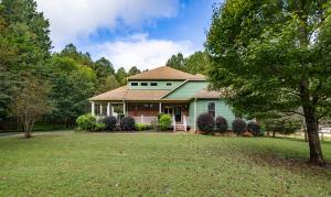 a green house with a tree in the yard at Cozy Lake Getaway with Firepit, Lake Access, Theatre in Boydton