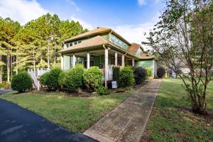 a green house with a pathway in front of it at Cozy Lake Getaway with Firepit, Lake Access, Theatre in Boydton