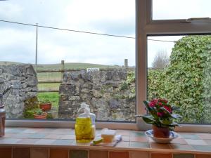 a window with a view of a stone wall at Forest View in Peak Forest +6 photos