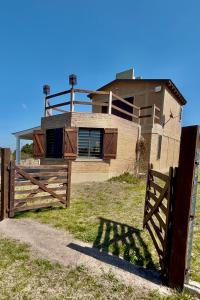 a house with a gate and a fence in front of it at Cabaña El Balcón in La Estancia +2 photos