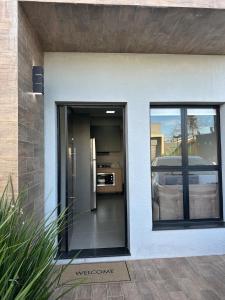a door to a house with a car outside at Loft Noruega 32 AC Garagem Privativa in Jaguarão