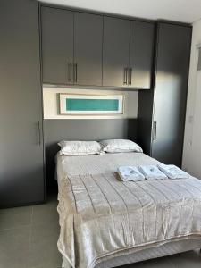 a bedroom with a bed with two towels on it at Loft Noruega 32 AC Garagem Privativa in Jaguarão
