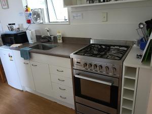 a kitchen with a stove and a sink at Woodlands Motel in Kerikeri