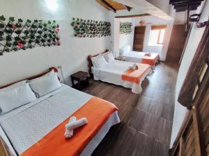 a room with two beds and a living room with at La tranquera hotel in Villa de Leyva