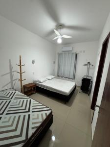 a bedroom with two beds and a ceiling fan at Residence Villa Vignoli in Arraial do Cabo +22 photos