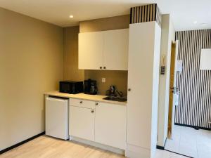 a kitchen with white cabinets and a sink at 4 person holiday home in SÖLVESBORG in Hällevik