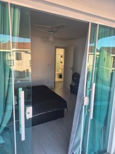 a bedroom with a bed and a glass wall at Casa in Saquarema