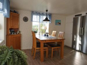 a kitchen with a wooden table with chairs and a refrigerator at 6 person holiday home in LYSEKIL in Torgestad +23 photos