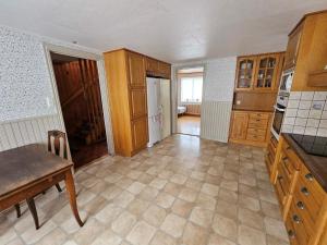 a kitchen with wooden cabinets and a table in it at 8 person holiday home in Ryssby in Ryssby