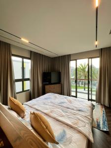 ein Schlafzimmer mit einem großen Bett mit Kissen darauf in der Unterkunft Tropical Villa Ho Tram in Xuyên Mộc