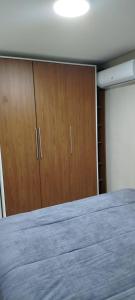 ein Schlafzimmer mit einem Bett und Holzschränken in der Unterkunft Lindo AP de 2 quartos e vaga de garagem 131 in São Leopoldo + 2 Fotos