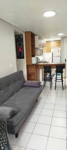 ein Wohnzimmer mit Couch und Küche in der Unterkunft Lindo AP de 2 quartos e vaga de garagem 131 in São Leopoldo