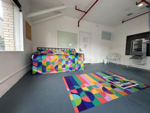 een kamer met een bed en een kleurrijk tapijt op de vloer bij The Art Nook Creative Hostel Room in the Heart of Hollywood Los Angeles in Los Angeles