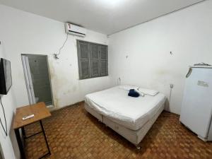 a bedroom with a bed and a table in it at Vana Hostel Familiar in Fortaleza