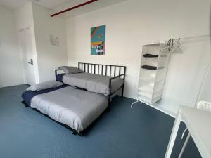 een slaapkamer met 2 bedden en een boekenplank bij The Art Nook Creative Hostel Room in the Heart of Hollywood Los Angeles in Los Angeles