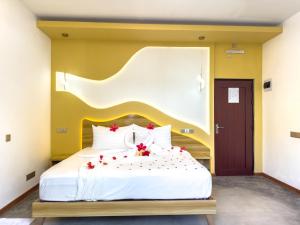 a bedroom with a large bed with red flowers on it at Thundi Villa in Maalhos
