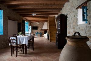 a dining room with a table and chairs at Domu Antiga in Gergei