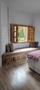 a room with a bench with a window in it at Casa de Campo Caminho do Petar - Rancho Quemeninho in Apiaí