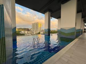 a swimming pool with a view of the water at Ddy & Mmy # Bay suites likas in Kota Kinabalu