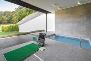 a room with a pool and a chair next to a house at Haeundae Beach Restfield in Busan
