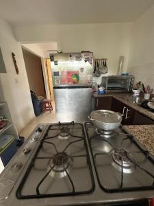 a stove top in a kitchen with a refrigerator at Habitacion amoblada frente al 99 de brisas del golf arraijan in ArraijÃ¡n