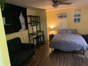 a bedroom with a bed and a couch and a chair at Private suite with small kitchen private bathroom entrance porch and driveway in Pinellas Park