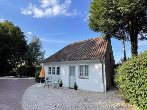 a small white house with a table and chairs at Gîte spacieux et moderne, à 12 km de Lille, avec toutes commodités, idéale pour une escapade tranquille - FR-1-510-208 in Linselles