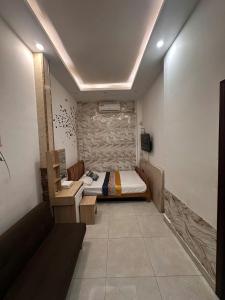 ein Schlafzimmer mit einem Bett und einer Bank darin in der Unterkunft Alleyway home in Ho-Chi-Minh-Stadt