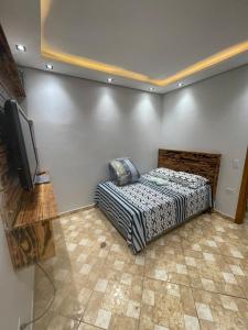 a bedroom with a bed and a flat screen tv at Private pool, spacious, barbecue in Londrina