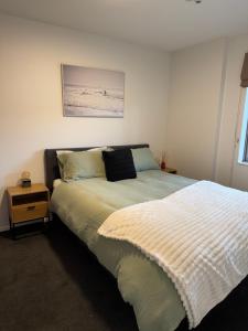 1 dormitorio con cama con colcha en Plantation apartment, en Wanaka