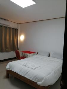 a bedroom with a large white bed and a table at ชมวิว บึงโขงหลง in Bung Khong Long