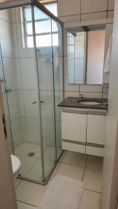 a bathroom with a glass shower and a sink at Apartamento Veneza in Franca +9 photos