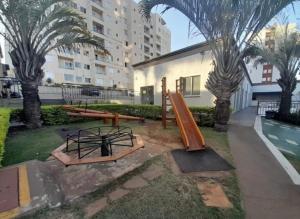 a playground with a slide and some palm trees at Apartamento Veneza in Franca