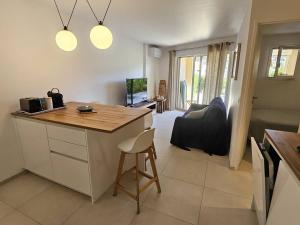 a kitchen and living room with a counter and a table at Ravissant T2 aux Issambres avec Piscine et Climatisation - FR-1-768-126 in La Garonnette-Plage
