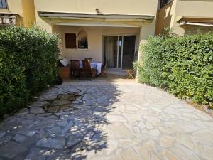 a stone walkway leading to a house with a table at Ravissant T2 aux Issambres avec Piscine et Climatisation - FR-1-768-126 in La Garonnette-Plage +2 photos