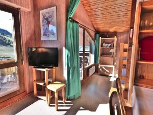 Il comprend un salon doté d'une télévision et d'une fenêtre. dans l'établissement Studio cosy pour 4 personnes avec balcon au Chinaillon - FR-1-458-257, au Chinaillon