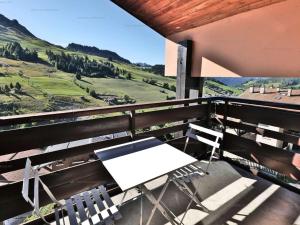 une table blanche et des chaises sur un balcon avec vue dans l'établissement Studio cosy pour 4 personnes avec balcon au Chinaillon - FR-1-458-257, au Chinaillon