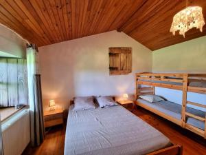 a bedroom with two bunk beds and a wooden ceiling at Gîte spacieux pour 12 personnes à Grammond, nature et confort - FR-1-496-373 in Chevrières