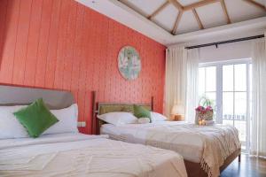 Bình TúにあるNovaWorld Phan Thiet Beachfont 2Room 3Bed 3Wcの赤い壁の部屋にベッドが2つある +24枚の写真