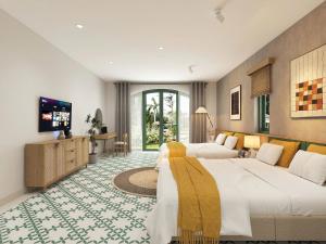 a hotel room with two beds and a flat screen tv at Plum Village Moc Chau in Mộc Châu